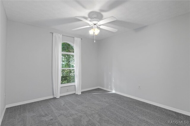 unfurnished room with carpet flooring, ceiling fan, and a textured ceiling