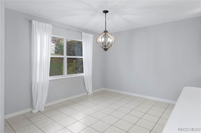 tiled empty room featuring an inviting chandelier