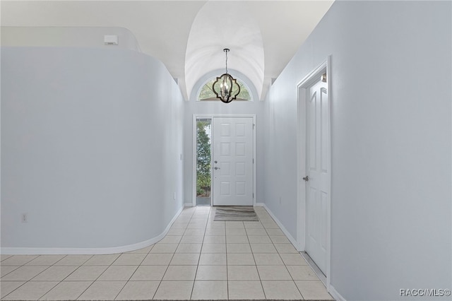 foyer with light tile patterned flooring, vaulted ceiling, and a chandelier