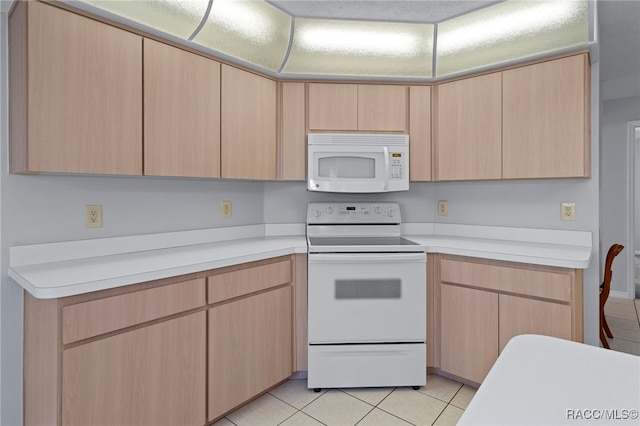 kitchen with light brown cabinetry, electric range, and light tile patterned flooring