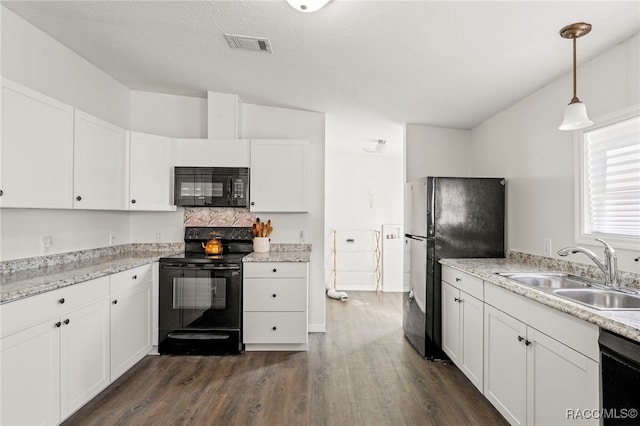 7187 Montier St, Weeki Wachee, FL 34613 - kitchen featuring black appliances, a sink, dark wood-style flooring, and white cabinetry