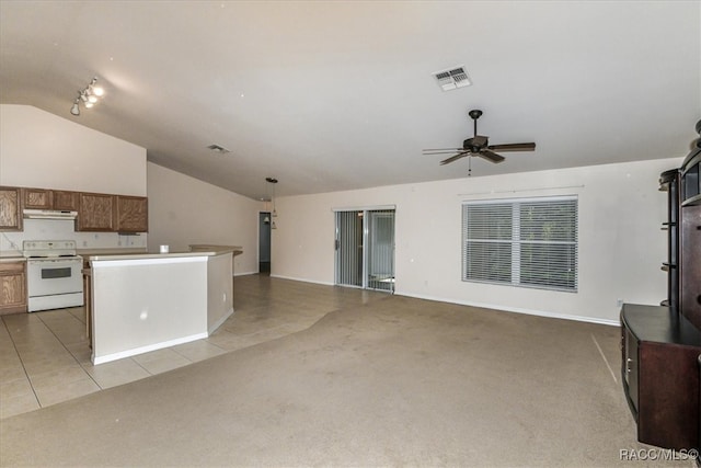 unfurnished living room featuring ceiling fan, light tile patterned floors, and vaulted ceiling