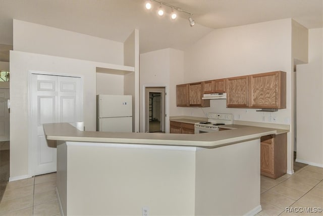 kitchen with lofted ceiling, light tile patterned flooring, a kitchen island, and white appliances