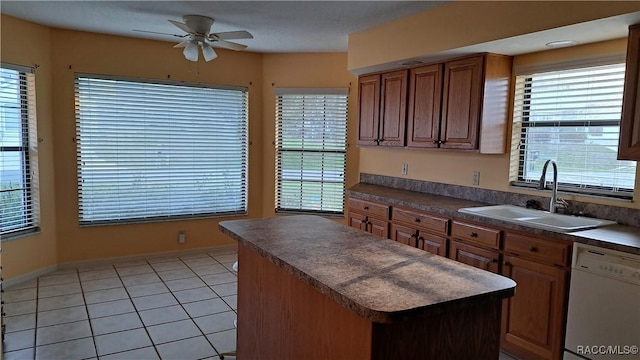 kitchen with light tile patterned floors, dark countertops, a center island, white dishwasher, and a sink