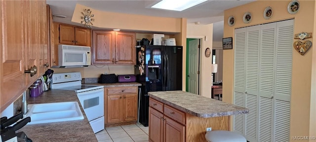 kitchen with light tile patterned flooring, white appliances, and a center island