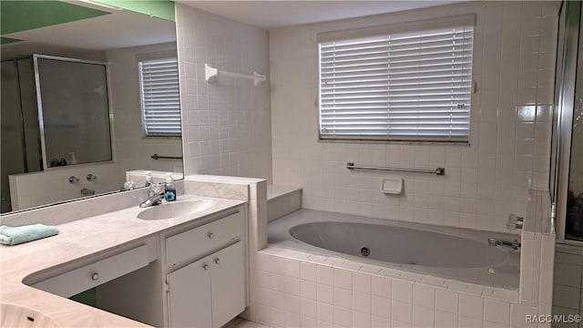 bathroom with vanity and shower with separate bathtub