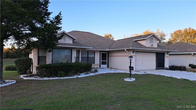 view of front facade featuring a garage, driveway, a front lawn, and stucco siding