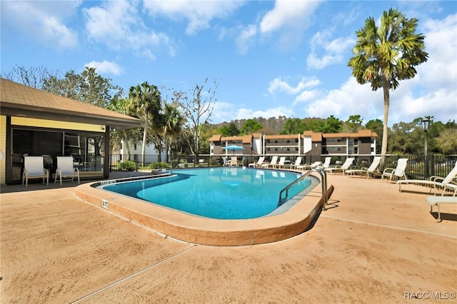 community pool featuring a patio area and fence