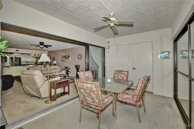 dining area featuring carpet flooring, ceiling fan, and a textured ceiling