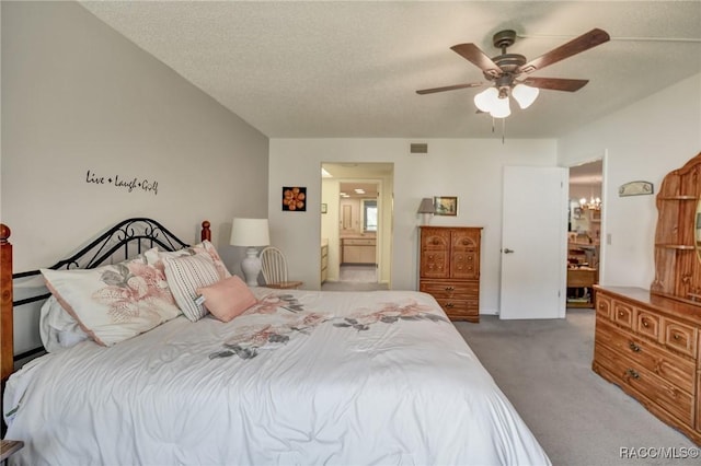 carpeted bedroom featuring visible vents, ceiling fan, a textured ceiling, and ensuite bath