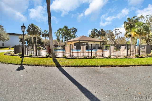 exterior space featuring a lawn, fence, and a pool