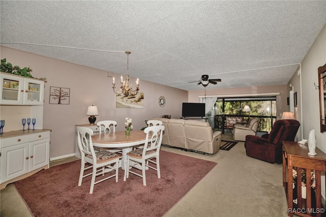 dining room with ceiling fan with notable chandelier, a textured ceiling, and carpet