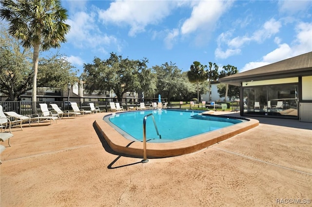 community pool featuring a patio area and fence