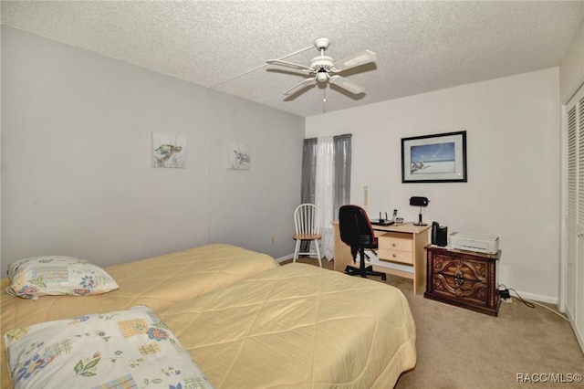 bedroom featuring baseboards, ceiling fan, a textured ceiling, carpet floors, and a closet