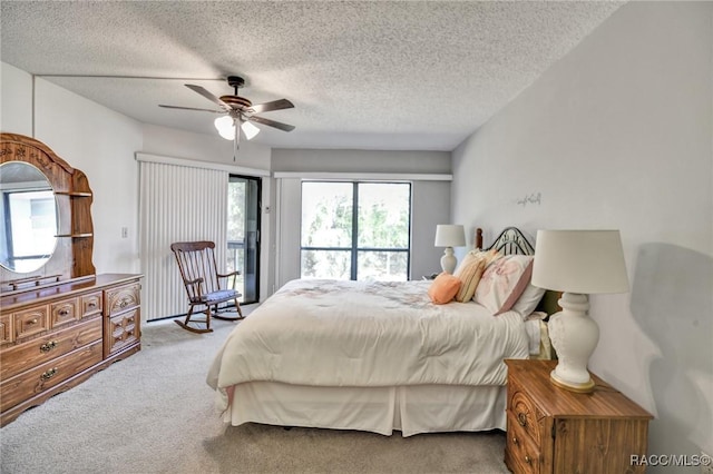 carpeted bedroom with access to outside, a textured ceiling, and a ceiling fan