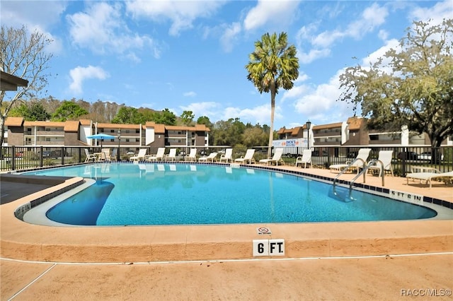 pool featuring a residential view, fence, and a patio