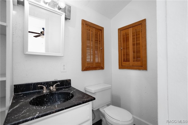 bathroom with vanity, ceiling fan, toilet, and lofted ceiling