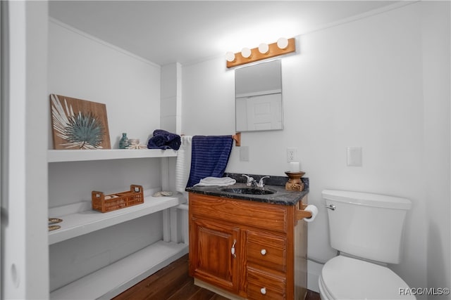 bathroom with toilet, vanity, and hardwood / wood-style flooring