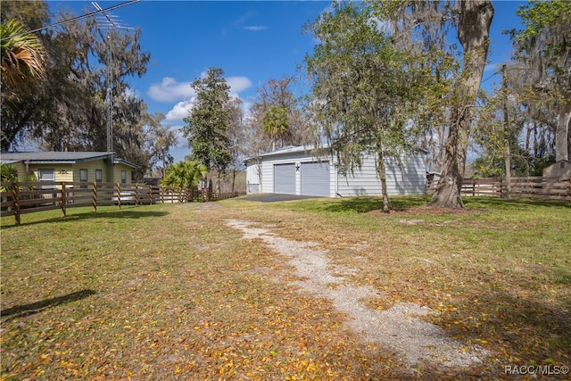 view of yard featuring a garage and an outbuilding