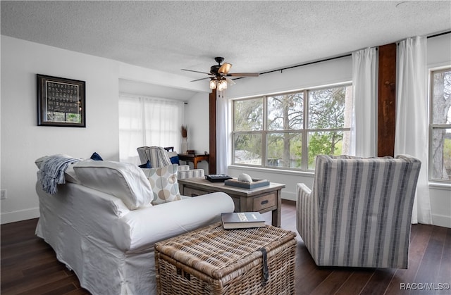 living room featuring plenty of natural light, ceiling fan, dark hardwood / wood-style flooring, and a textured ceiling