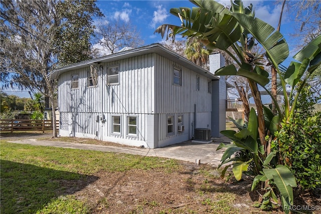 back of house with a lawn, central AC unit, and a patio