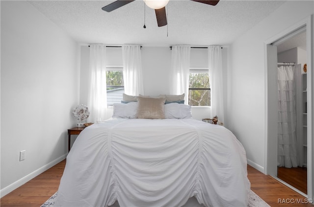 bedroom featuring ceiling fan, hardwood / wood-style floors, and a textured ceiling