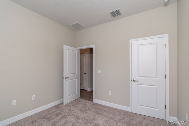 unfurnished bedroom featuring light carpet