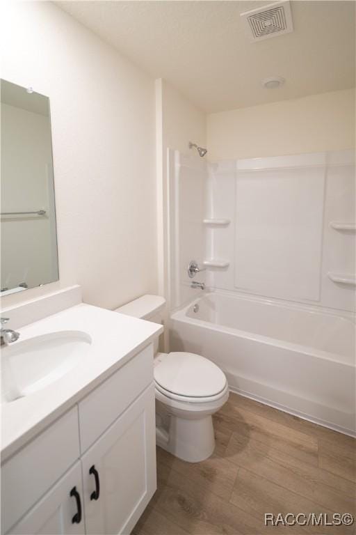 full bathroom featuring vanity, toilet, shower / bathing tub combination, and hardwood / wood-style flooring