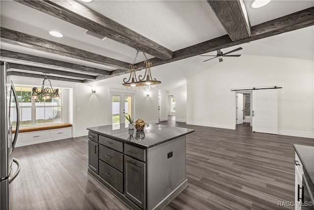 kitchen with dark hardwood / wood-style flooring, a barn door, a kitchen island, and plenty of natural light