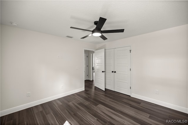 unfurnished bedroom with visible vents, dark wood finished floors, a closet, baseboards, and ceiling fan