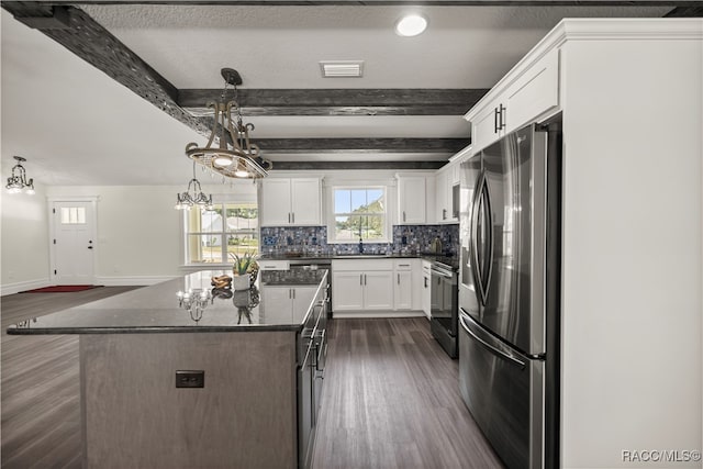 kitchen featuring hanging light fixtures, beamed ceiling, a kitchen island, white cabinetry, and stainless steel appliances