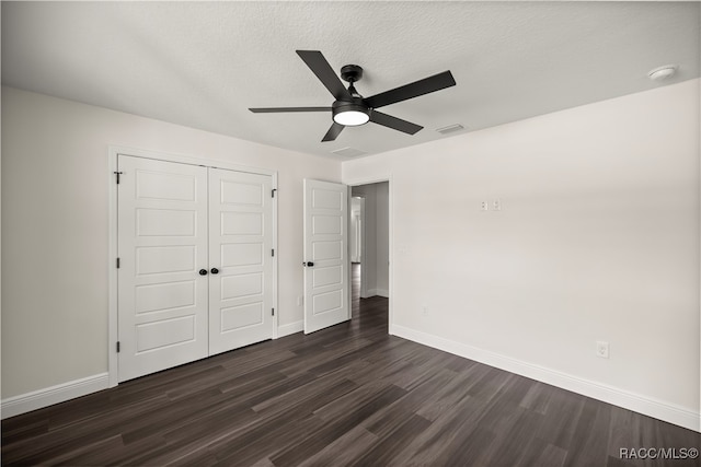 unfurnished bedroom featuring a ceiling fan, baseboards, visible vents, dark wood-type flooring, and a closet