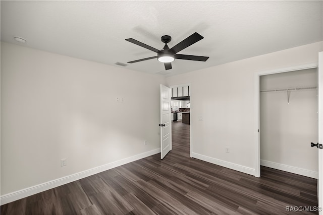 unfurnished bedroom with visible vents, dark wood-type flooring, baseboards, a closet, and a ceiling fan