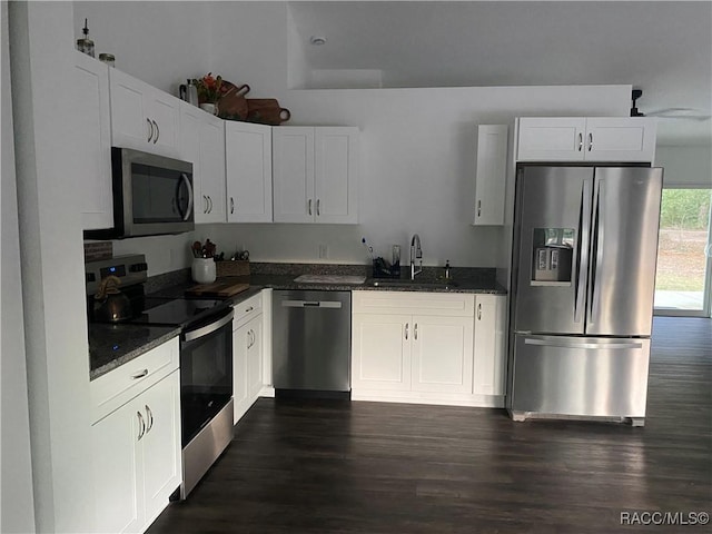 kitchen featuring white cabinets, dark stone countertops, sink, and appliances with stainless steel finishes