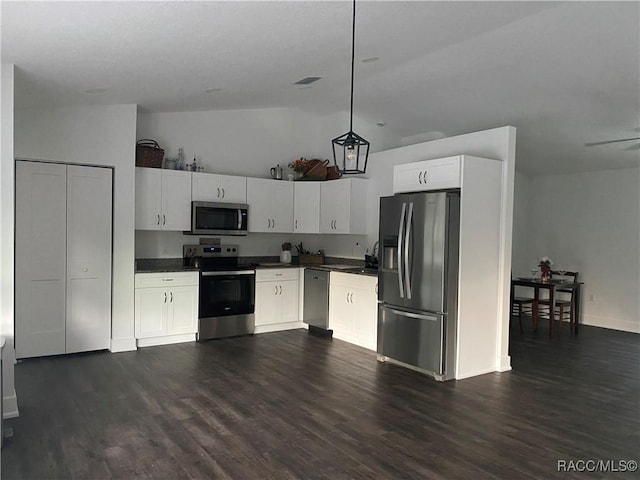 kitchen with stainless steel appliances, dark hardwood / wood-style floors, white cabinetry, hanging light fixtures, and lofted ceiling