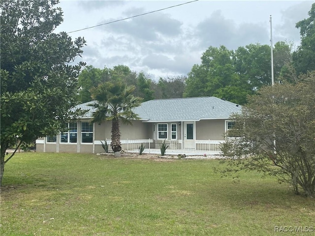 rear view of house featuring a lawn