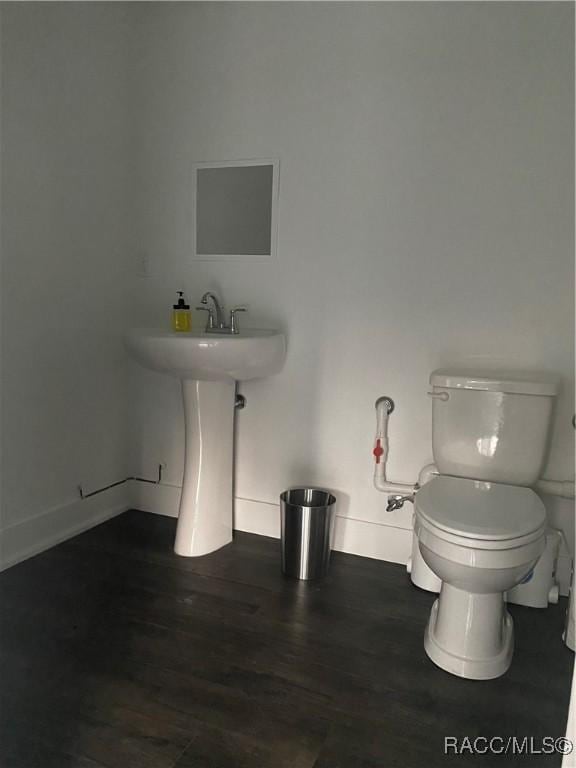 bathroom with hardwood / wood-style floors, toilet, and sink