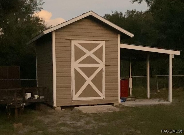 outdoor structure at dusk featuring a carport