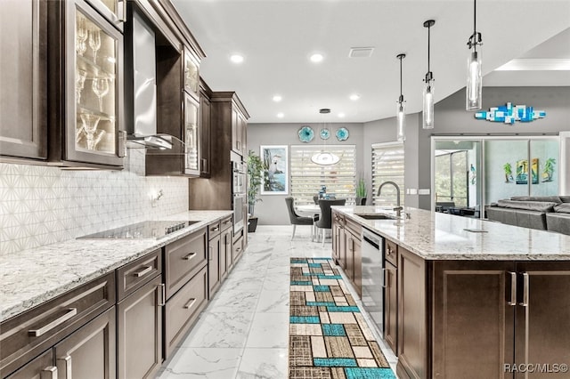 kitchen featuring black electric cooktop, a spacious island, sink, wall chimney range hood, and hanging light fixtures