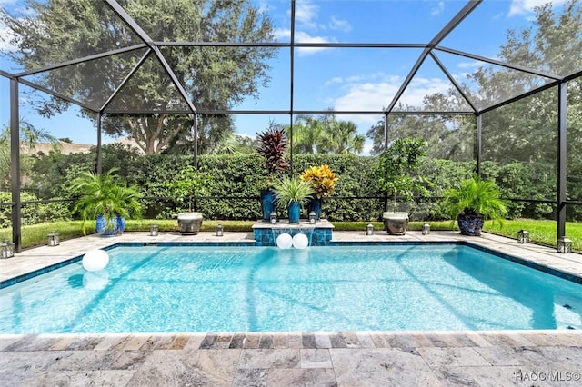 view of pool featuring glass enclosure and a patio area