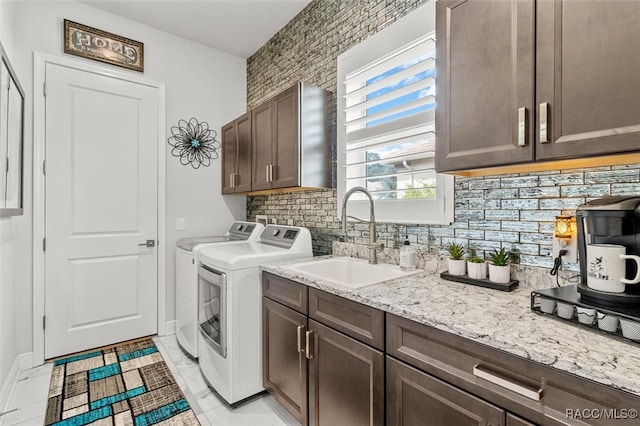 laundry area with washer and dryer, sink, light tile patterned flooring, and cabinets