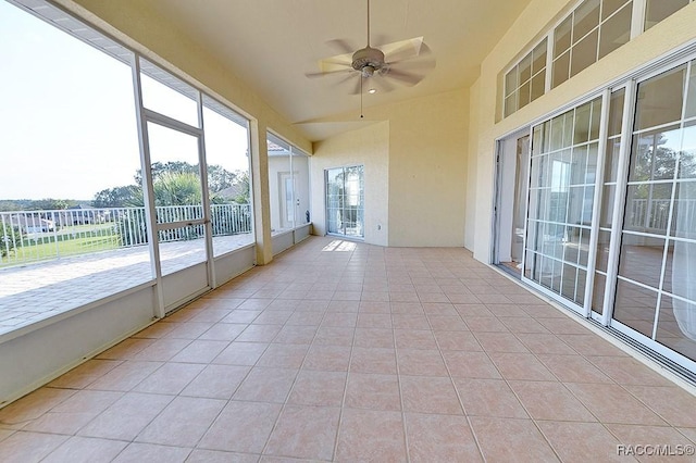 unfurnished sunroom featuring ceiling fan