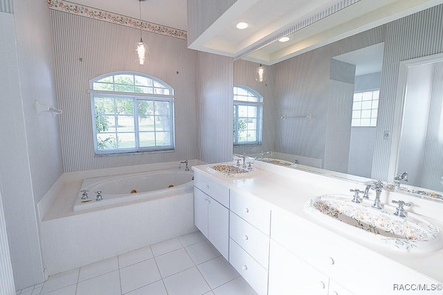 bathroom with tile patterned floors, vanity, and a relaxing tiled tub