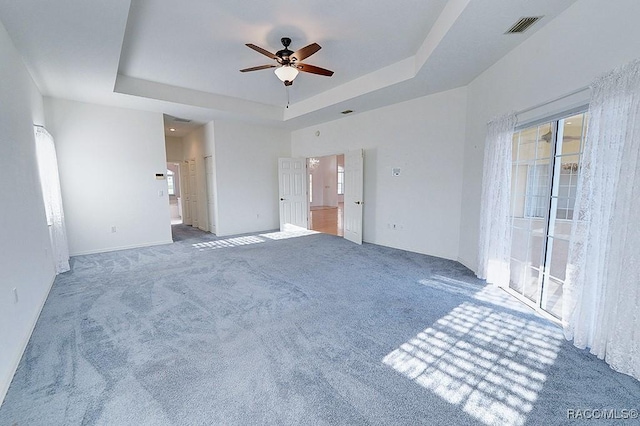 unfurnished bedroom featuring carpet flooring, connected bathroom, ceiling fan, and a raised ceiling