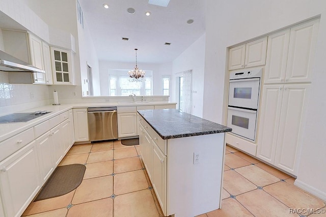 kitchen featuring double oven, dishwasher, black electric stovetop, a kitchen island, and white cabinetry