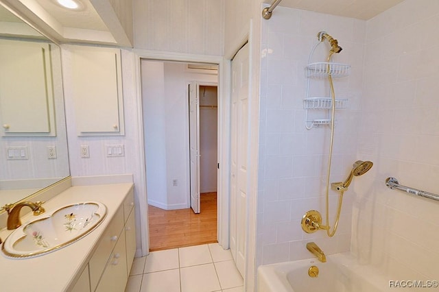 bathroom with tile patterned floors, vanity, and tiled shower / bath