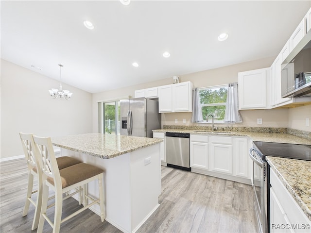 178 W Navarro Pl, Citrus Springs, FL 34434 - kitchen featuring stainless steel appliances, light wood finished floors, a center island, a sink, and white cabinetry