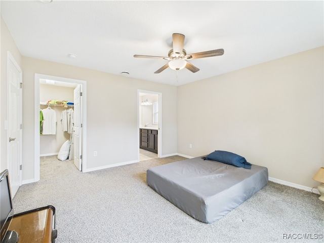 178 W Navarro Pl, Citrus Springs, FL 34434 - bedroom with light carpet, baseboards, a ceiling fan, ensuite bath, and a walk in closet