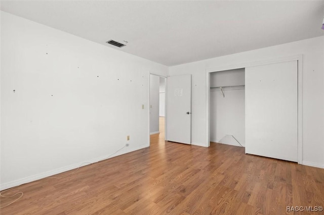 unfurnished bedroom featuring a closet and light hardwood / wood-style flooring