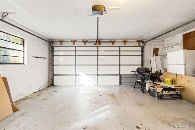 garage featuring a garage door opener and white refrigerator